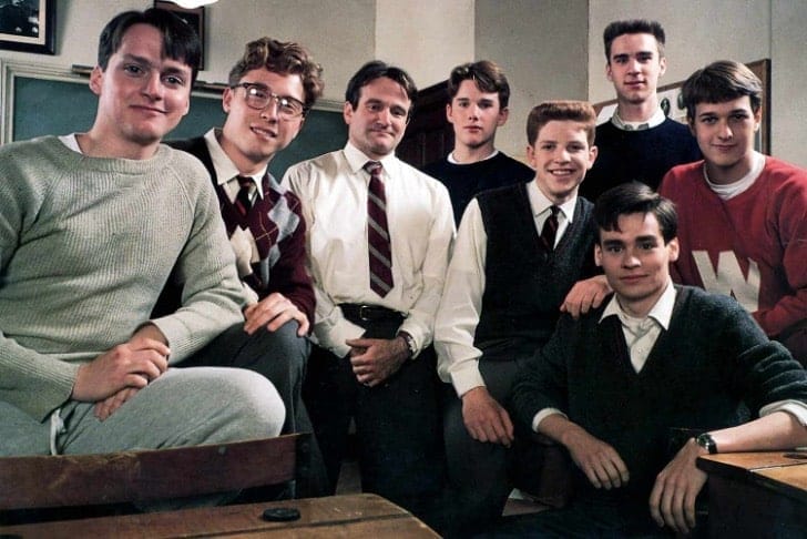 Actor and comedian, Robin Williams, standing in the center of a group of young men posing for a photo. From the set of Dead Poet's Society. 
