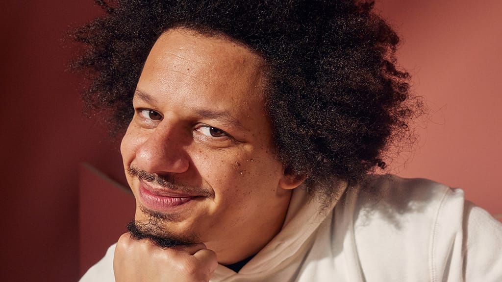 Image of American comedian and actor, Eric Andre with curly hair, smiling for a portrait. He would make a great version of the Mad Hatter for a remake of the TV movie, Alice in Wonderland, originally aired in 1999.