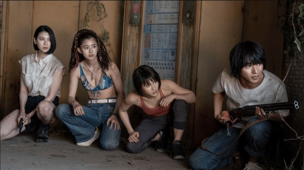 Characters from the Netflix science fiction series "Alice in Borderland" crouch and look around a corner while holding guns.