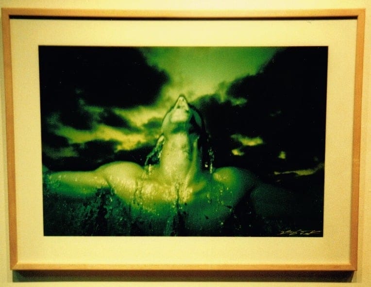 Photograph by Eshel Ezer of a man coming out of the water tinted in green. 