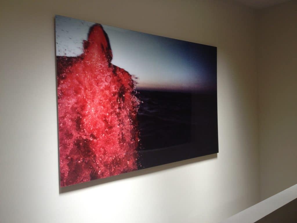 Photograph of a man coming out of the water with the sea in the background by Eshel Ezer. 