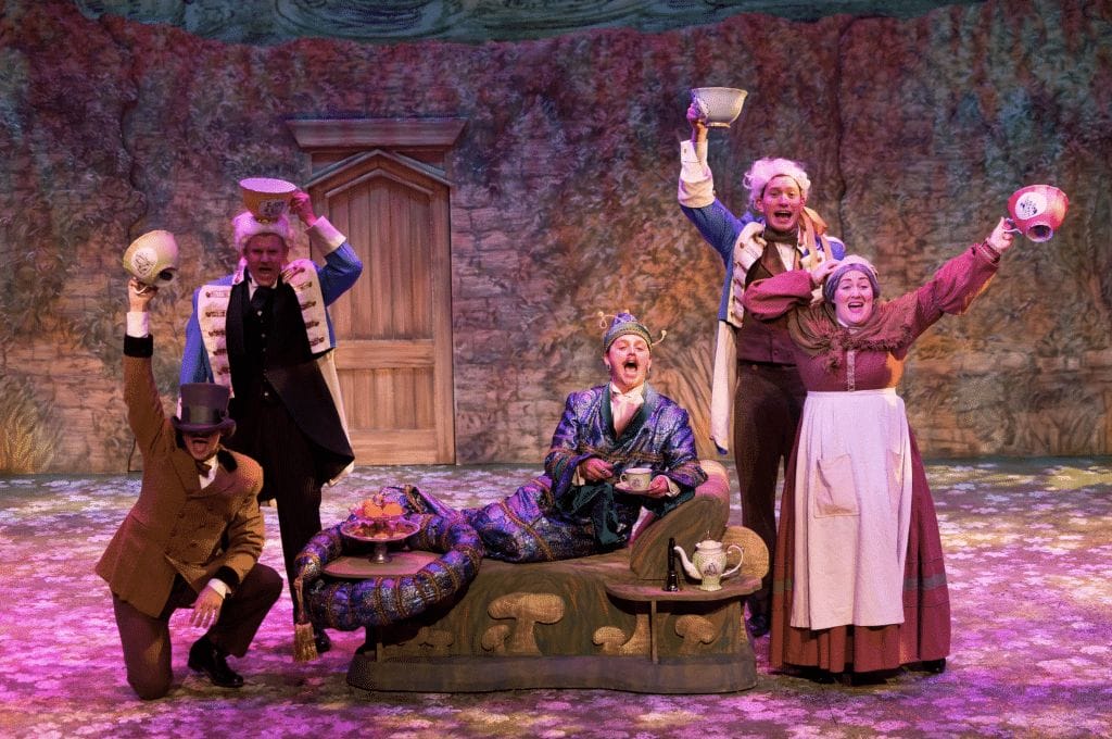 A still image featuring the Caterpillar and other company members from the production of the musical "Alice, Formerly of Wonderland".